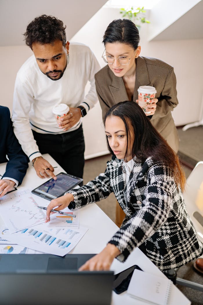 Team of professionals analyzing financial data with graphs and devices in a modern office.